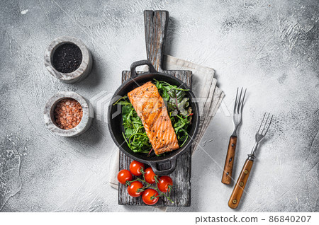 Salmon fillets, grilled steaks in skillet with herbs. White background. Top view 86840207