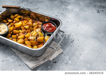 Patatas bravas traditional Spanish potatoes snack tapas in a steel tray. Gray background. Top view. Copy space 86840438