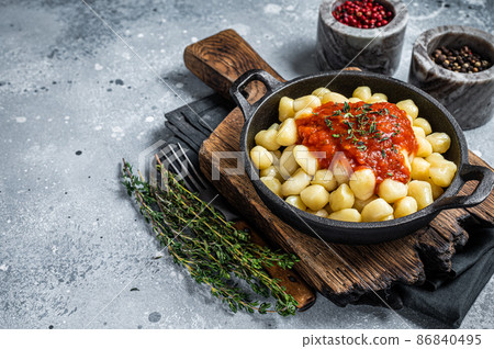 Gnocchi pasta with tomato sauce and parmesan. Gray background. Top view. Copy space 86840495