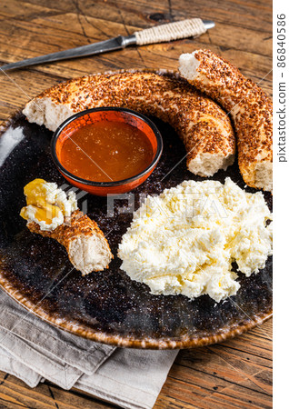 Tradirional Turkish breakfast - kaymak clotted cream, bagel simit and honey. Wooden background. Top view 86840586