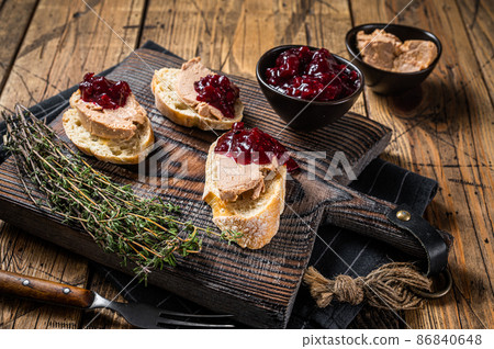 French cuisine Foie gras toasts, goose liver pate and lingonberry marmalade. wooden background. Top view 86840648