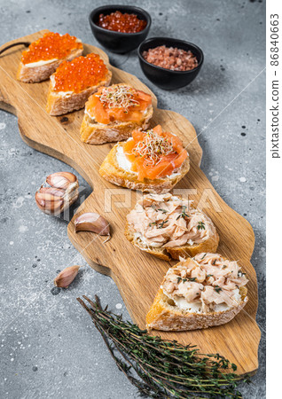 Smoked salmon and red caviar toasts appetizer with cream cheese. Gray background. Top view 86840663
