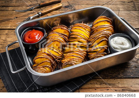 Skewered fried tornado or twist potatoes with ketchup sauce. Wooden background. Top view Skewered fried tornado or twist potatoes with ketchup sauce. Wooden background. Top view 86840668