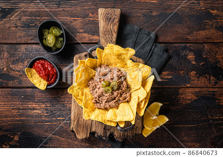 Mexican Baked nachos with chili con carne in a skillet. Wooden background. Top view 86840673