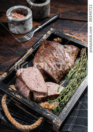 Grilled Tri Tip steak, sirloin bottom beef in a tray with herbs. Wooden background. Top view Grilled Tri Tip steak, sirloin bottom beef in a tray with herbs. Wooden background. Top view 86840722