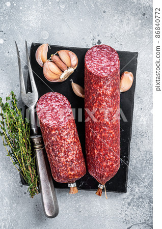 Dry salami sausage with fresh thyme. Gray background. Top view 86840772