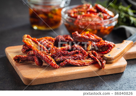 Sun dried tomatoes on cutting board. Sun dried tomatoes on cutting board. 86840826