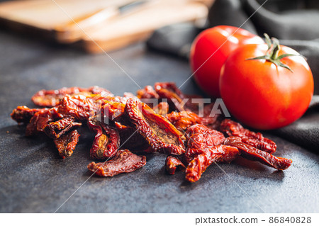 Sun dried tomatoes on black table. Sun dried tomatoes on black table. 86840828