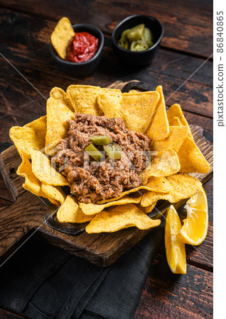Mexican Baked nachos with chili con carne in a skillet. Wooden background. Top view 86840865