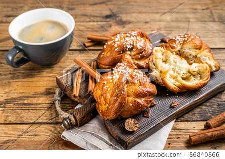 Breakfast with Cinnamon buns or rolls, Swedish Kanelbullar. wooden background. Top view Breakfast with Cinnamon buns or rolls, Swedish Kanelbullar. wooden background. Top view 86840866