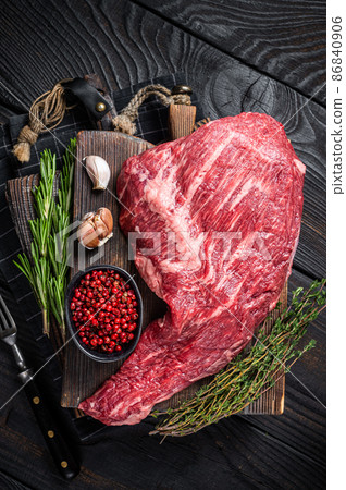 Tri Tip black angus beef steak on cutting board with herbs, raw meat. Black Wooden background. Top view Tri Tip black angus beef steak on cutting board with herbs, raw meat. Black Wooden background. Top view 86840906