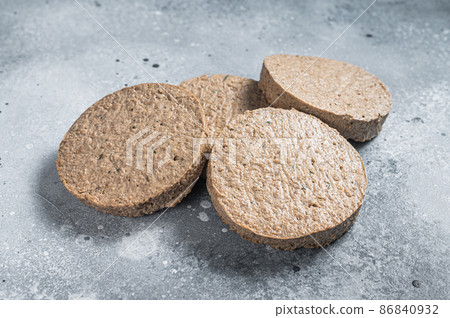 Raw Meat Free Plant Based Burger patties, vegetarian cutlets. Gray background. Top view Raw Meat Free Plant Based Burger patties, vegetarian cutlets. Gray background. Top view 86840932