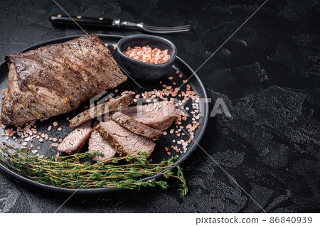 Barbecue dry aged wagyu Tri Tip beef steak on a plate with pink salt. Black background. Top view. Copy space Barbecue dry aged wagyu Tri Tip beef steak on a plate with pink salt. Black background. Top view. Copy space 86840939
