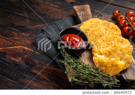 Hash brown potato, Potato Patties on a wooden board with ketchup. Wooden background. Top view. Copy space Hash brown potato, Potato Patties on a wooden board with ketchup. Wooden background. Top view. Copy space 86840972