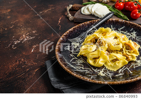 Vegetarian ravioli Pasta with Mozzarella, parmesan cheese and Tomato. Dark background. Top view. Copy space 86840993