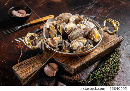 Garlic white wine shells Clams, vongole in a skillet with herbs. Dark background. Top view Garlic white wine shells Clams, vongole in a skillet with herbs. Dark background. Top view 86840995