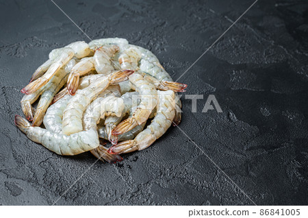 Fresh raw black shrimps prawns on a stone Board. Black background. Top view. Copy space Fresh raw black shrimps prawns on a stone Board. Black background. Top view. Copy space 86841005