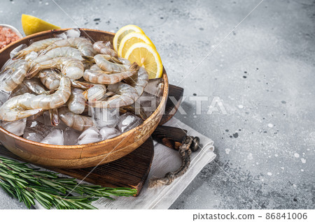 Uncooked Raw peeled tiger white shrimp prawn. Gray background. Top view. Copy space Uncooked Raw peeled tiger white shrimp prawn. Gray background. Top view. Copy space 86841006