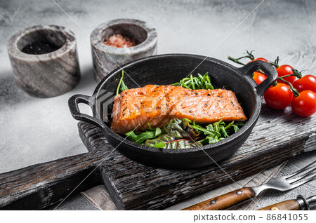 Salmon fillets, grilled steaks in skillet with herbs. White background. Top view Salmon fillets, grilled steaks in skillet with herbs. White background. Top view 86841055