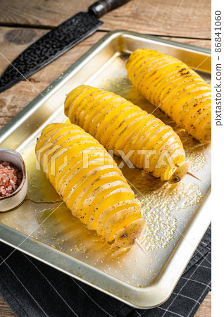 Uncooked raw Tornado or Twist potato fries. Wooden background. Top view 86841060