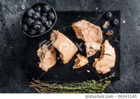 Foie gras duck liver pate and fresh blueberry. Black background. Top view 86841140