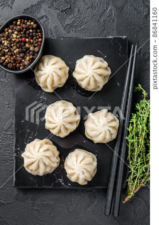 Chinese baozi dumplings on a marble board. Black background. Top view Chinese baozi dumplings on a marble board. Black background. Top view 86841160