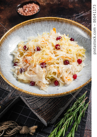 Fresh healthy sauerkraut in bowl with black pepper and cranberry. Dark background. Top view 86841173