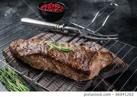 BBQ grilled tri tip beef steak on a grill. Black background. Top view BBQ grilled tri tip beef steak on a grill. Black background. Top view 86841262