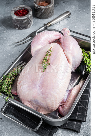 Whole raw Free range chicken in kitchen tray with herbs. Gray background. Top view 86841315