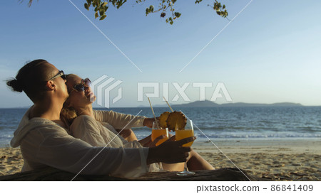 Loving couple in white dress, sunglasses, in hugging, relax and 86841409