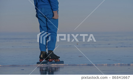 The girl train on ice speed skating. The child skates in the winter in blue sportswear suit, sport glasses. Children speed skating sport. 86841667