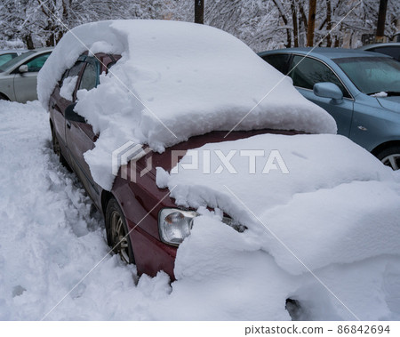 Car under a big snowdrift in winter. Car under a big snowdrift in winter. 86842694
