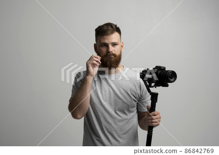 Bearder videographer filmmaker cinematographer dop with 3-axis gimbal and dslr camera. Filmmaking, videography, hobby and creativity concept. 86842769