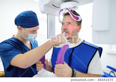 Doctor dentist are going to do a digital x-ray with man patient in dentistry clinic. Panoramic radiography. Modern professional dental equipment Doctor dentist are going to do a digital x-ray with man patient in dentistry clinic. Panoramic radiography. Modern professional dental equipment 86842835