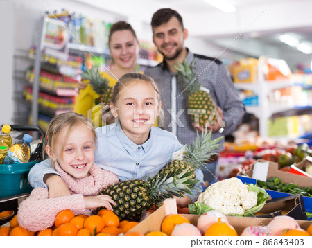Happy parents with little girls with pineapples 86843403