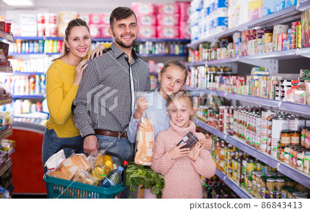 spouses with two children holding full basket 86843413