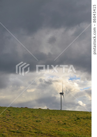 wind energy tubin on top of a hill with large cloudy sky copy space wind energy tubin on top of a hill with large cloudy sky copy space 86843415