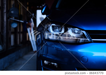 Headlights of a blue car in a garage Headlights of a blue car in a garage 86843770