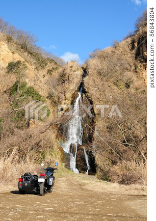 A sidecar standing against the backdrop of a falling waterfall 86843804