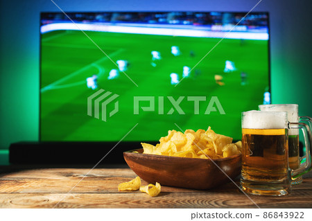 Beer and snacks set on football match tv background Beer and snacks set on football match tv background 86843922