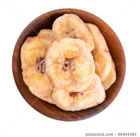 Banana chips in wooden bowl, isolated on white background. Dried fruit snack. Top View. 86844365