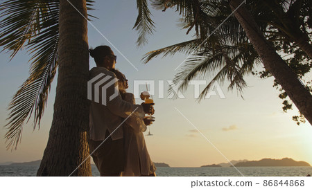The man hugs a woman. Loving couple near palm tree, kissing, hug The man hugs a woman. Loving couple near palm tree, kissing, hug 86844868