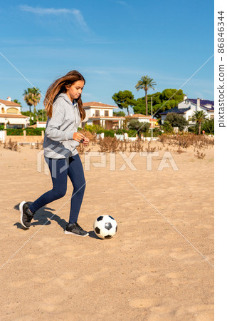 Happy little girl on the beach plays with a ball on the sand. Travel and leisure Happy little girl on the beach plays with a ball on the sand. Travel and leisure 86846344