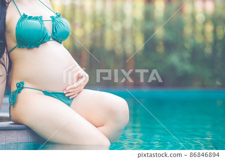 Beautiful pregnant woman at the summer swimming pool with bikini. 86846894