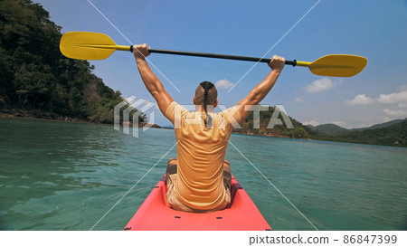 Man with thin plait hairstyle rows pink plastic kayak putting up Man with thin plait hairstyle rows pink plastic kayak putting up 86847399