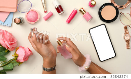 Female beauty blogger workspace with a female spraying a perfume on her wrist. 86848274