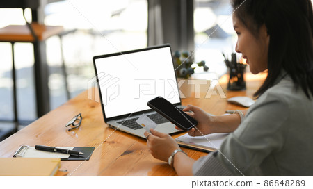 A female typing a credit card number on smartphone 86848289