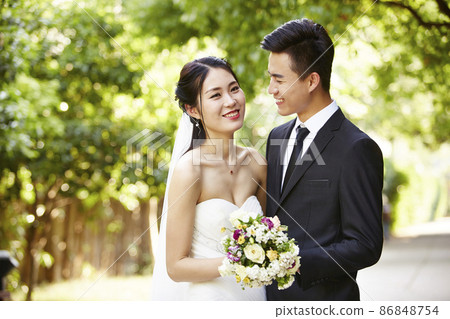 outdoor portrait of asian bride and groom, happy and smiling 86848754