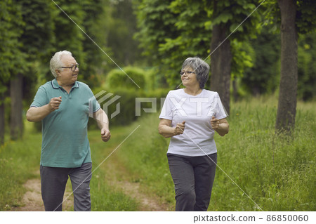 Active Elderly Couple Exercising Outdoors In Athletic Attire