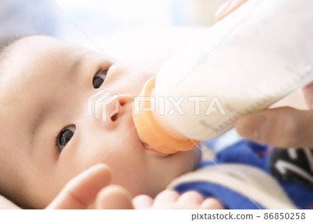 亞洲嬰兒從嬰兒奶瓶裡喝牛奶 86850258